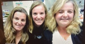 Three people side by side seen through a laptop screen