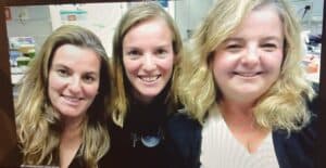 Three people side by side seen through a laptop screen
